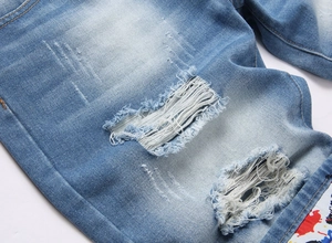 Détail du short en jean bleu clair délavé avec déchirures et doublure camouflage