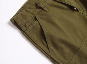 Détail du short cargo vert olive avec texture en sergé et braguette à glissière en métal