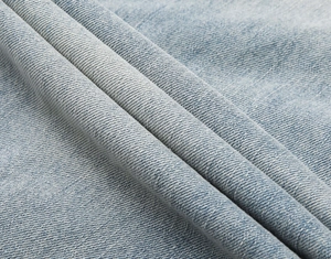 Vista dettagliata del tessuto denim blu lavato pesante con trama a saia definita