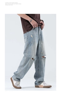Gros plan d'un jean bleu délavé avec détails déchirés aux genoux et coupe jambe large