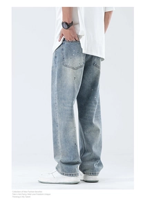 Details von hellblau gewaschenen Jeans mit künstlerischen weißen und grünen Farbspritzern