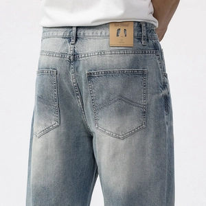 Men's loose straight leg jeans in light blue washed denim with premium leather waist patch