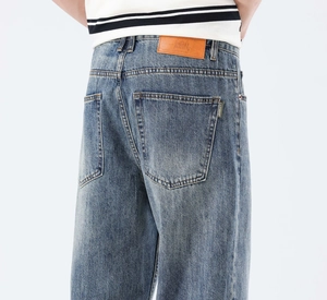 Vue arrière du jean délavé vintage montrant l'écusson en cuir orange à la taille