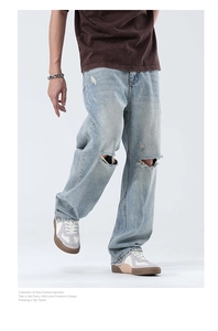Détail du jean large bleu clair pour homme avec déchirures stylées au niveau du genou