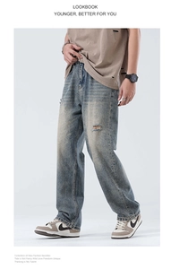 Close-up of vintage blue washed denim fabric with ripped details and whiskers on jeans