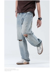 Détail de la déchirure naturelle sur le jean délavé bleu clair à coupe large pour homme