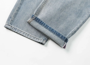 Dettaglio dell'orlo in denim blu lavato con cuciture di qualità e bordo colorato