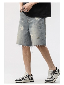 Détail du short en jean délavé avec imprimés étoiles, déchirures et bords effilochés