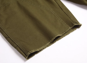 Gros plan détaillé du tissu denim vert armée montrant le sergé et l'ourlet effiloché