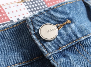 Détail du short en jean bleu avec bouton métallique et doublure motif drapeau américain