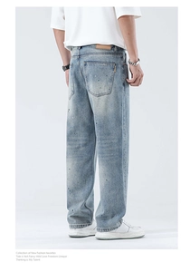Detailansicht der hellblauen Jeans mit Farbspritzern und braunem Lederpatch an der Taille