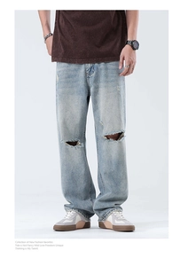 Détail d'un jean large bleu clair avec genoux déchirés et style urbain américain lavé