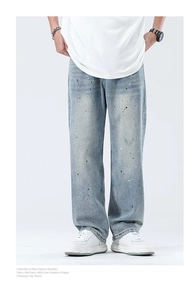 Detail der hellblauen Jeans mit künstlerischen Farbspritzern und Vintage-Waschung