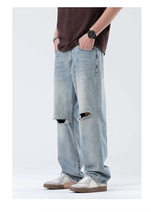 Détail des déchirures aux genoux sur un jean droit bleu clair pour homme style vintage