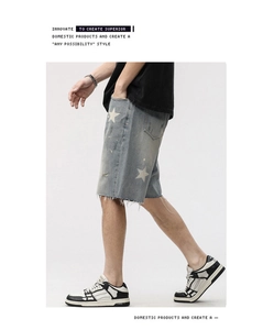 Détail du short en jean avec bords effilochés et motif étoile en délavage vintage