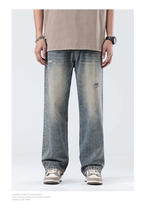 Detail of vintage blue distressed jeans featuring faded whiskers and retro washed denim fabric