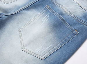 Détail de la poche arrière du short en jean avec coutures jaunes et délavage usé