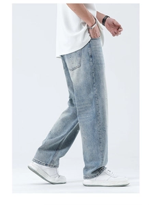 Detailansicht der hellblau gewaschenen Denim-Jeans mit Farbspritzern und lockerem Schnitt