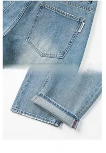 Détail du jean délavé bleu clair avec étiquette de poche et ourlet à lisière rouge
