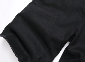 Détail du short en jean noir avec ourlet à bords francs et poche plaquée surpiquée