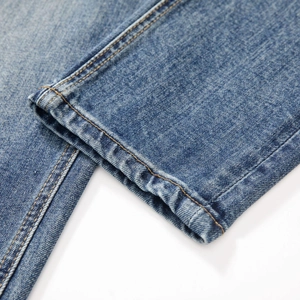 Jean denim stretch bleu ajusté avec détails de couture à double aiguille sur l'ourlet
