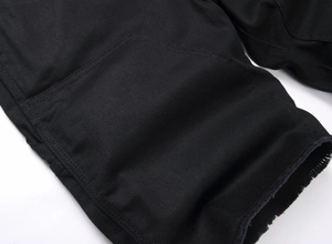 Gros plan d'un short en jean noir avec texture sergé et ourlets bruts effilochés tendance