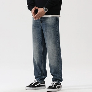 Detail of loose straight leg jeans with vintage wash and distressed cat whisker texture