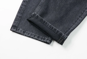 Détail de l'ourlet roulé et du tissu denim gris délavé sur ce pantalon en coton de qualité