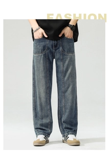 Detail view of vertical double stitching and curved pockets on deep blue washed jeans