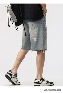 Détail du short en jean avec imprimés étoiles blanches et ourlet effiloché vintage