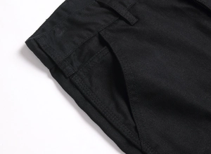 Détail macro des coutures de la poche avant sur un short en jean noir pour hommes