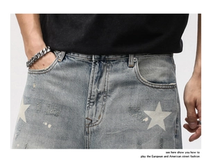 Détail d'imprimé étoile sur short en jean délavé effet usé avec moustaches vintage et trous