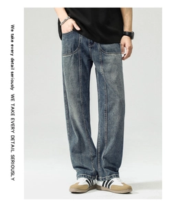Detailed close-up of dark blue washed denim wide leg pants with vertical seam details