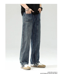 Detail of dark blue wide leg jeans featuring large patch pockets and vertical stitching