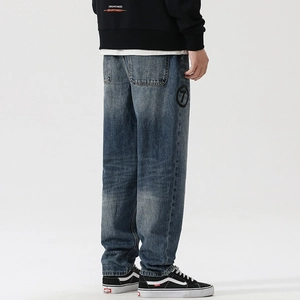 Detail of vintage blue wide-leg jeans featuring a custom number seven patch and wash texture