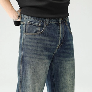 Détail du tissu denim délavé bleu vintage avec rivets métalliques et coutures contrastées