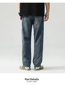 Detail view of back pockets and faded wash finish on men's dark blue wide-leg jeans