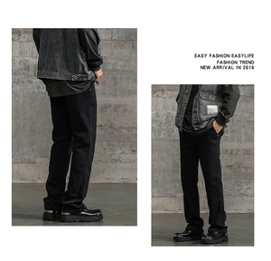 Dettaglio posteriore dei pantaloni denim neri svasati da uomo stile streetwear chic