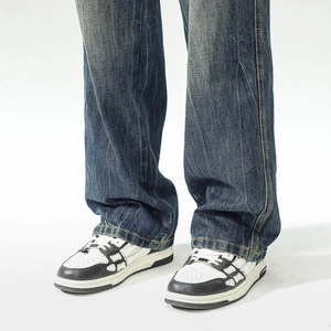 Détail de jean droit bleu foncé délavé avec baskets à empiècements squelette