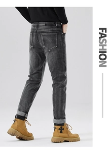 Detailansicht der Gesäßtaschen und des Lederaufnähers bei schmal geschnittenen grauen Jeans
