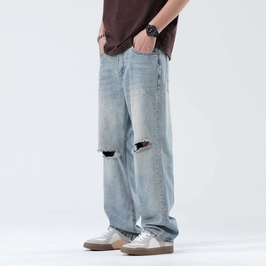 Men's light blue distressed wide leg jeans with ripped knees and loose straight fit style