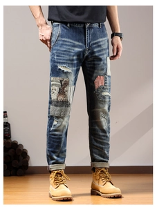 Detailed patchwork and distressed elements on dark blue straight-leg denim jeans