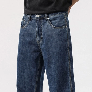 Detailed macro view of the vintage washed dark blue denim waist and metal button