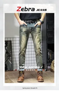 Detail of slim straight retro dirty wash jeans paired with brown leather work boots