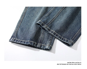Detail view of heavy washed dark blue denim leg openings with vintage distressed textures