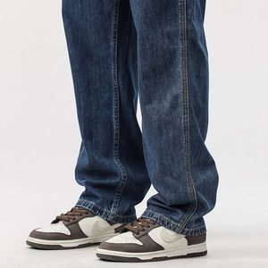 Detail of vintage washed navy blue denim trousers with reinforced side double stitching