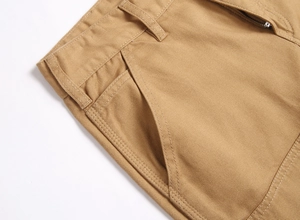 Gros plan du short en jean kaki montrant les passants de ceinture et les coutures de poche