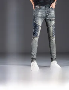 Detail of slim fit denim jeans featuring knee stitching and decorative thigh zippers
