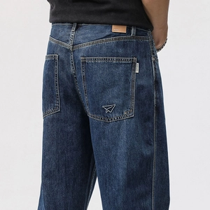 Detail of vintage blue straight jeans featuring white airplane embroidery on the back pocket