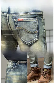 Detail view of vintage light blue jeans with curved stitching and red logo on back pocket